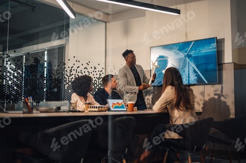 Preview: Diverse businessman presenting wind turbine prototype to team of experts