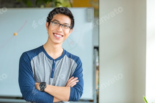Preview: Portrait Of A Happy Asian Male Student Standing With Arms Folded In University