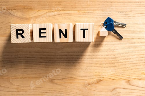 Preview: top view of keys with key chain near cubes with rent lettering on wooden table