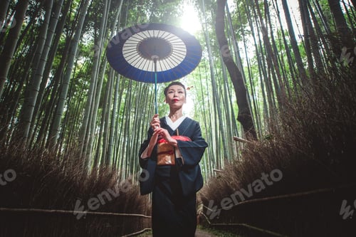 Preview: Beautiful japanese senior woman walking in the bamboo forest