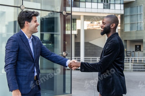 Preview: Multicultural businessmen shaking hands in city financial district