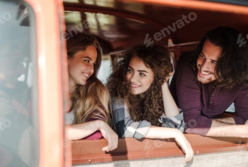 Preview: A group of young friends on a roadtrip through countryside, looking out of window.