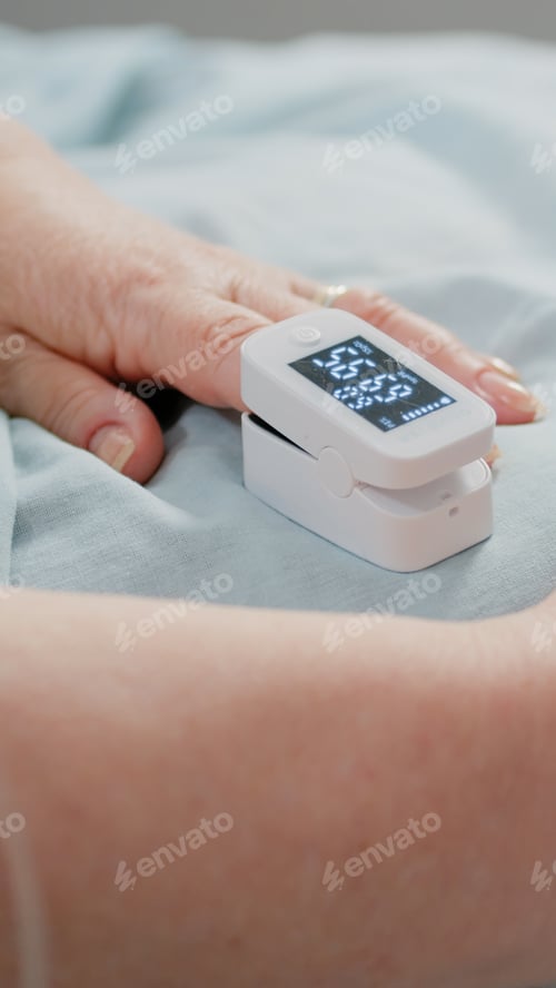 Preview: Close up of oximeter on finger showing low oxygen saturation