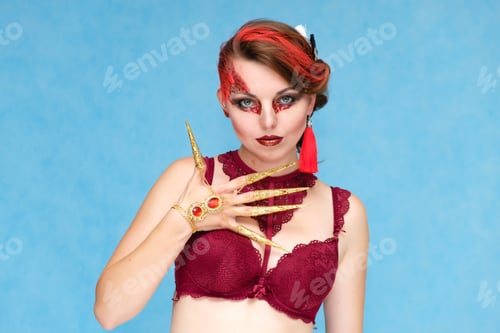 Preview: Portrait Waist-Up Against A Blue Background Of A Pretty Young Brunette Woman With Beautiful Makeup