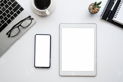 Preview: Top view tablet and smartphone blank white screen on the workbench at office. Mock up.