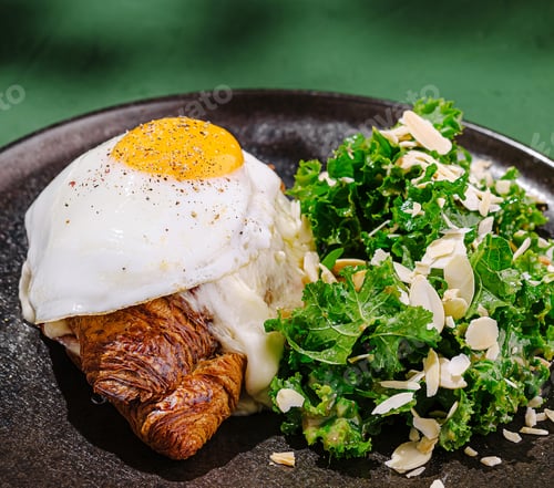 Preview: Delicious breakfast croissant topped with egg and side salad