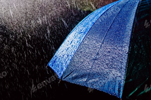 Preview: Multicolored umbrella under raindrops isolated on black as background.