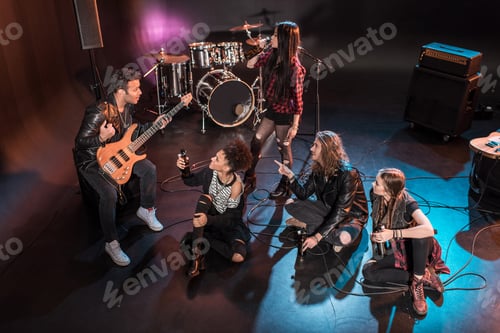 Preview: Young rock and roll band drinking beer after concert on stage