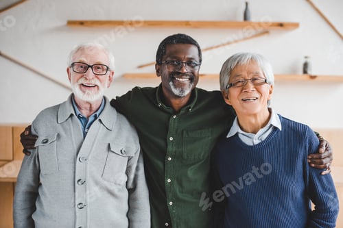 Preview: group of multiethnic senior friends embracing and looking at camera