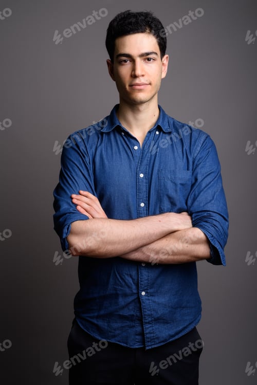 Preview: Portrait of young handsome businessman against gray background
