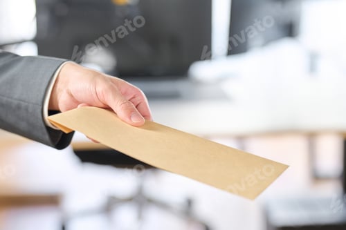 Preview: Businessman holding out an envelope
