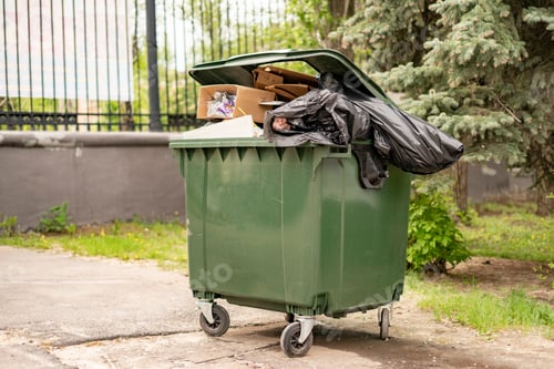 Vista previa: metal green old fulled with trash garbage container, nature pollution concepts