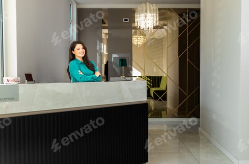 Preview: Portrait of female receptionist at desk in lobby.