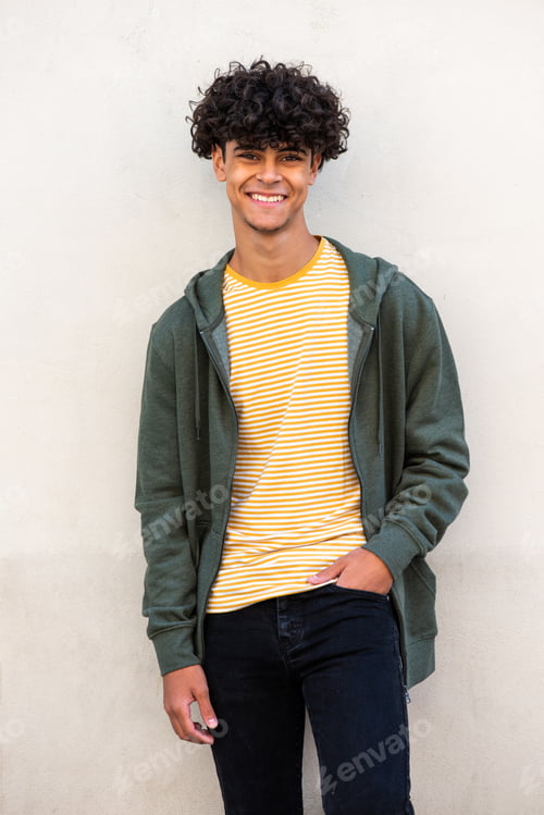 Preview: smiling young man posing by white wall