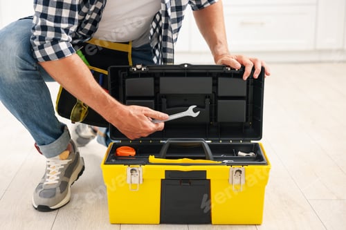 Preview: Man taking wrench from tool box indoors, closeup