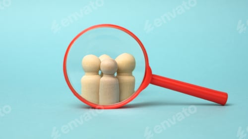 Preview: Wooden figurines of men and a red magnifying glass on a blue background. Recruitment for the company