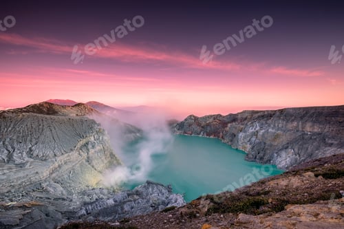 Preview: Active crater volcano with smoke of sulphur in turquoise lake with colorful sky at morning