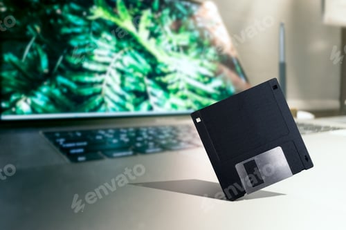 Preview: Old tech Floppy disk placed on Modern laptop