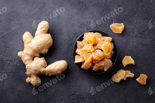 Preview: Candied ginger in black bowl on dark stone background. Top view.