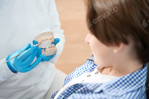 Preview: Boy with Orthodontist Discussing Braces in a Clinic