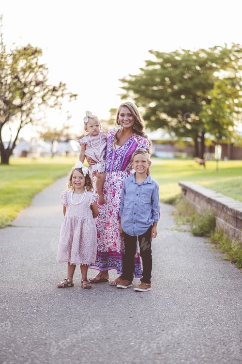 Preview: Vertical shot of a beautiful mom with her adorable kids in a park
