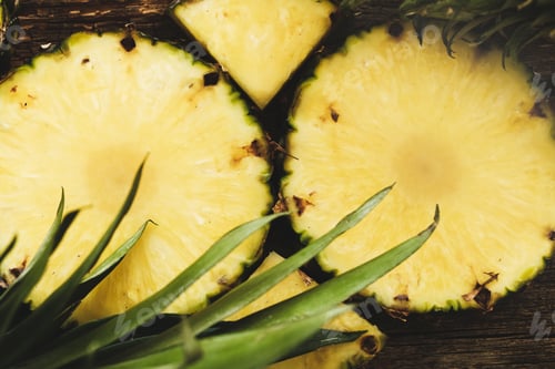 Cut Pineapple Slices on a Wooden Board