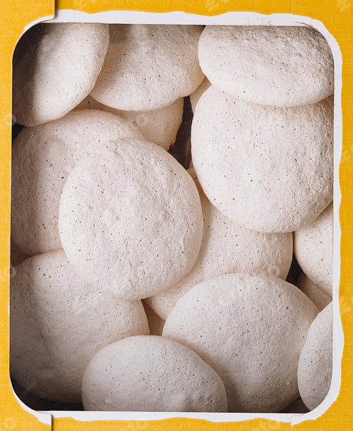 Preview: Box of vanilla meringue cookies close up background