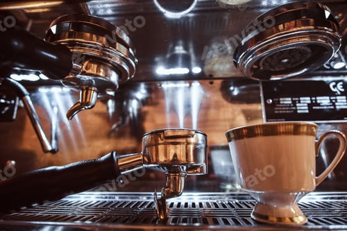 Preview: Portafilter and cup with cappuccino next to a coffee machine in the restaurant of a coffee shop