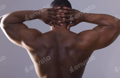 Preview: Studio shot of an unrecognisable muscular man posing against a grey background