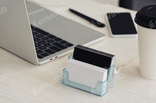 Preview: card holder with black and white empty business cards, laptop and smartphone with blank screen on