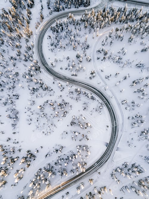 Preview: Aerial view of Curvy Windy Road in snow covered forest in Winter Finland