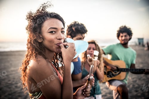Preview: Group of friends having fun on the beach making a bonefire