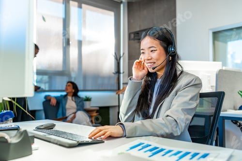 Preview: Asian businesswoman working with headset in coworking office