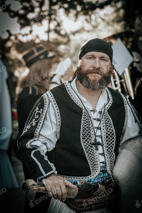Preview: Man wearing medieval clothing with an elaborate beard and black outfit