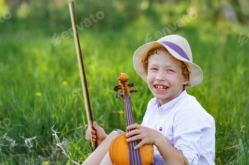 Preview: Boy playing violin outside classroom, Portrait of child boy playing the violin in park background.