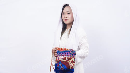 Preview: Asian muslim woman wearing prayer beads and prayer mat in white background