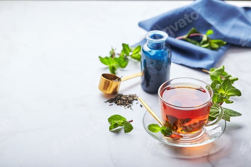 Preview: Black tea in glass transparent mug with mint leaves. Soothing tea, anti-stress