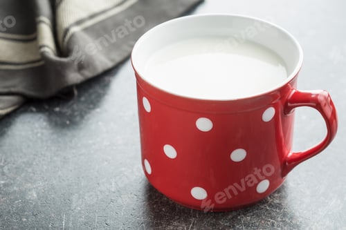 Preview: Milk in red mug with white spots.