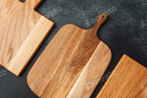 Preview: Wooden cutting boards displayed on a dark kitchen countertop for culinary use