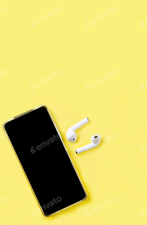 Preview: Black headphones and smartphone on yellow paper background