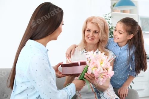 Preview: Woman and her daughter congratulating granny at home. Happy Mother's Day