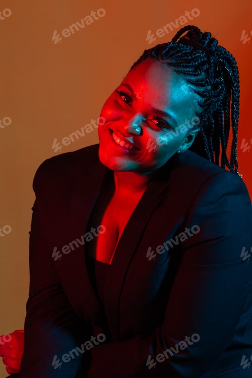 Preview: Close up beauty fashion portrait of an attractive young african woman wearing dreadlocks over orange