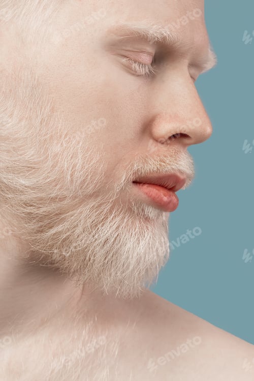 Preview: Closeup shot of bearded albino man with closed eyes, white hair and pale skin over turquoise studio