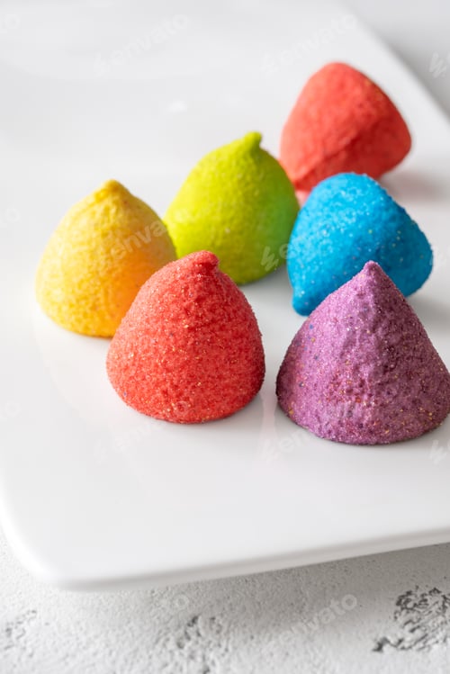 Preview: Colorful sugar-coated marshmallow pyramid candies sparkling on clean white rectangular platter