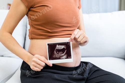 Preview: Pregnant hold with ultrasound baby photo at home