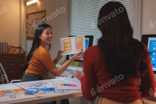 Preview: Asian web designers working on user interface of mobile application