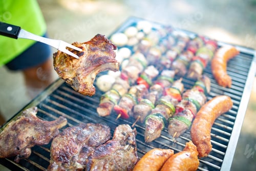 Preview: Assorted meat from chicken, pork and various vegetables on barbecue grill