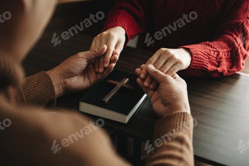Preview: Two people reading and study bible in home and pray together.Studying the Word Of God With Friends.