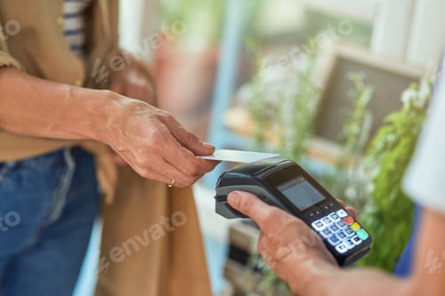Preview: Woman paying with bank card in shop