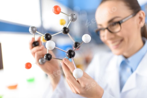 Preview: smiling scientist holding molecular model in laboratory, focus on foreground